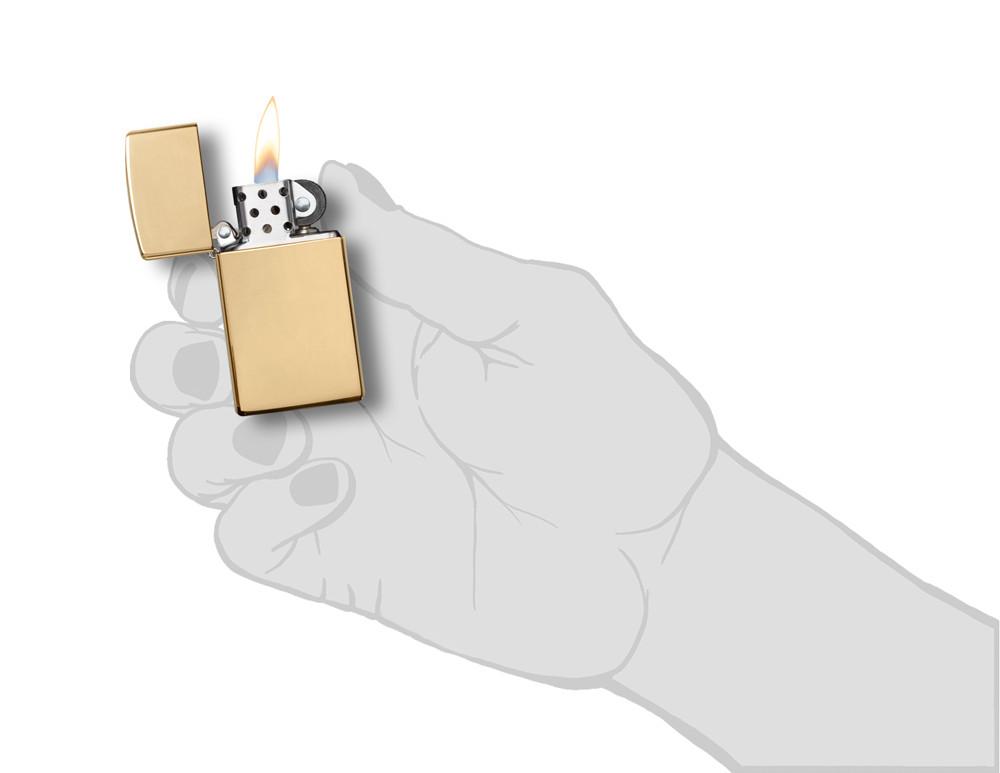 Vooraanzicht Zippo aansteker Slim Brass High Polished basismodel geopend met vlam in gestileerde hand